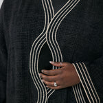 Black abaya with white embroidery trim on a plain background