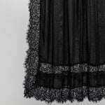 Black sheer lace skirt with a textured pattern and a wide lace hem, shown against a plain light gray background.