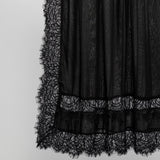 Black sheer lace skirt with a textured pattern and a wide lace hem, shown against a plain light gray background.