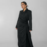 Woman wearing a black ruched abaya on a gray background