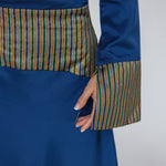 Blue dress with patterned trim on a plain background