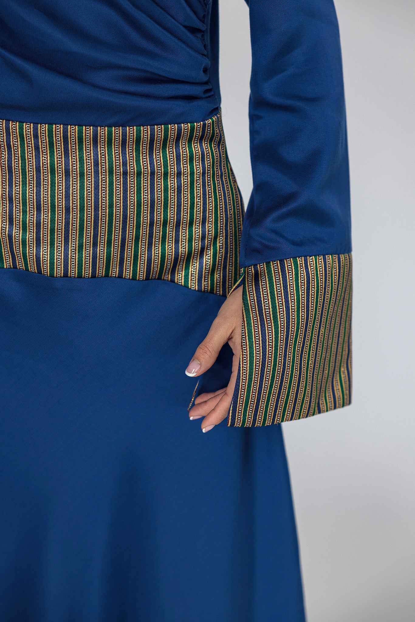 Blue dress with patterned trim on a plain background
