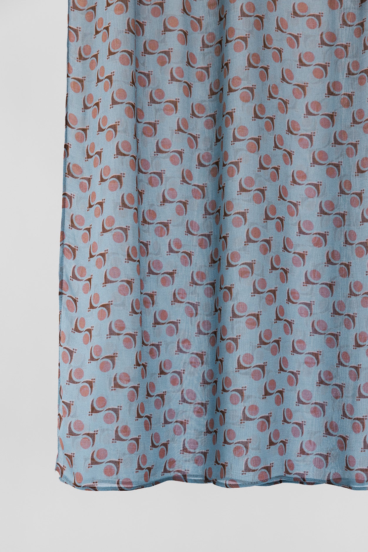 Fabric with a pattern of small shapes on a light blue background