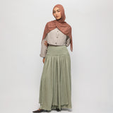 Woman wearing a hijab and long braided cascade skirt on a white background