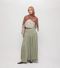 Woman wearing a hijab and long braided cascade skirt on a white background
