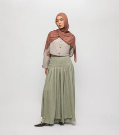 Woman wearing a hijab and long braided cascade skirt on a white background