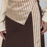 Brown skirt with a striped detail worn by a person on a plain background