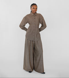 Person wearing a brown outfit with wide-leg pants on a white background