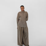 Person wearing a brown herringbone outfit on a white background