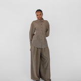 Person wearing a brown herringbone outfit on a white background