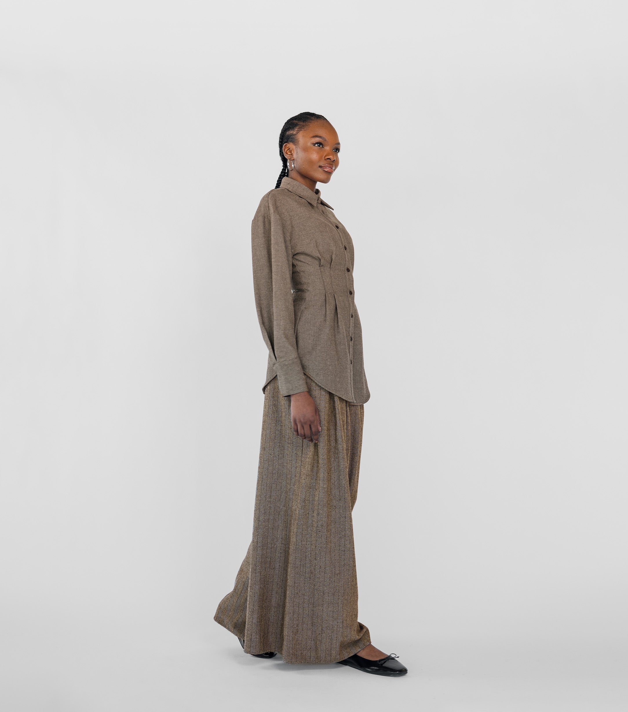 Woman wearing a brown suit with a white background
