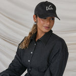 Person wearing a black cap with 'Vela' branding against a neutral background