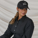 Person wearing a black cap with 'Vela' branding against a neutral background