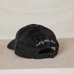 Black cap with text "3rd culture kid" on a beige surface