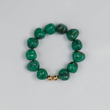 Green beaded hoop with a gold clasp on a light gray background.