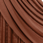Close-up of draped brown fabric with soft folds and a slightly textured surface, shown against a small white background.