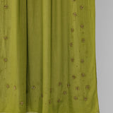 Green fabric with gold embroidery on a white background