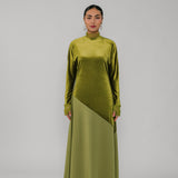 Woman wearing a green velvet dress on a gray background