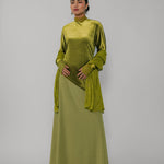 Woman wearing a green dress with a plain background