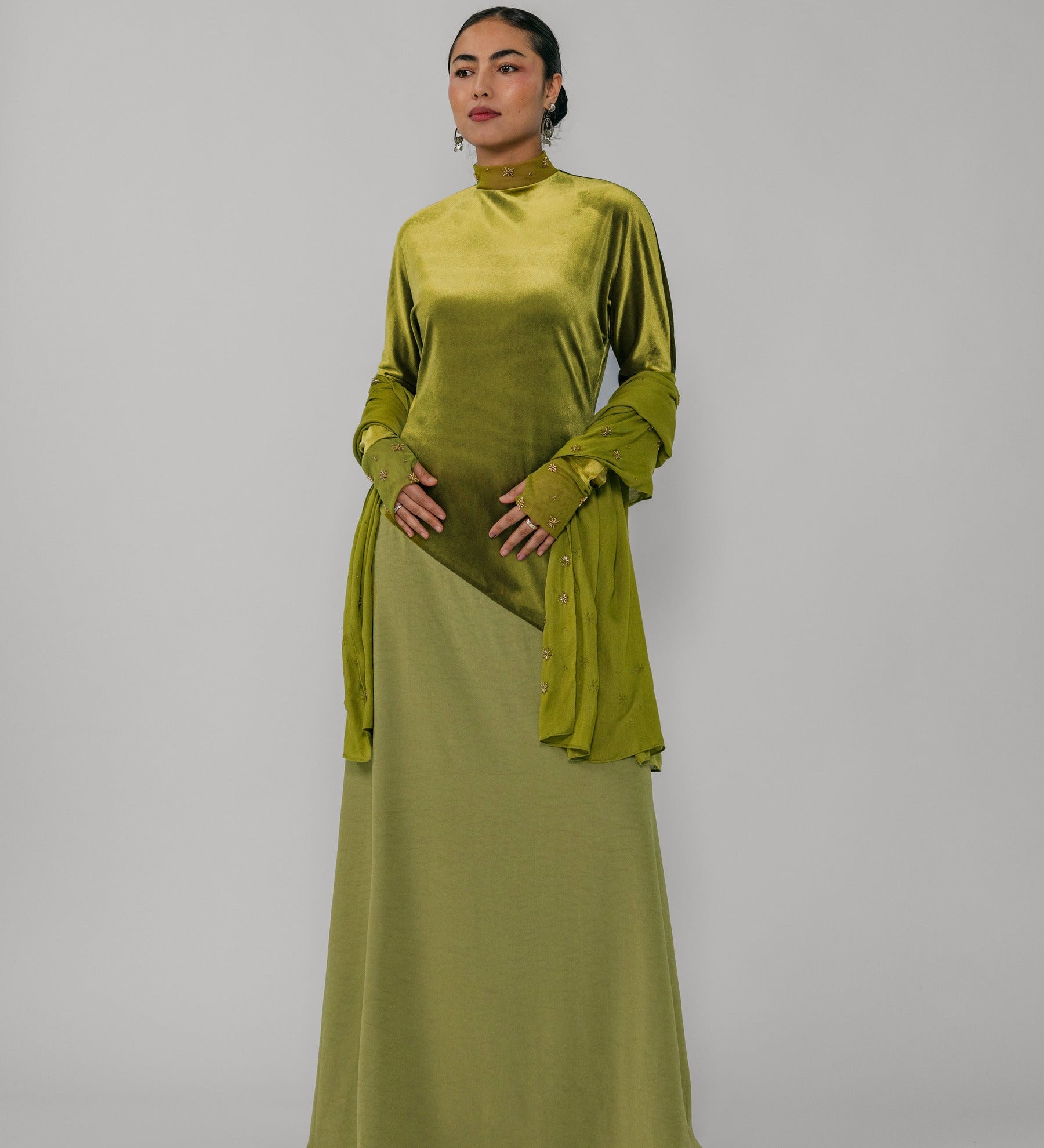 Woman wearing a green dress with a plain background