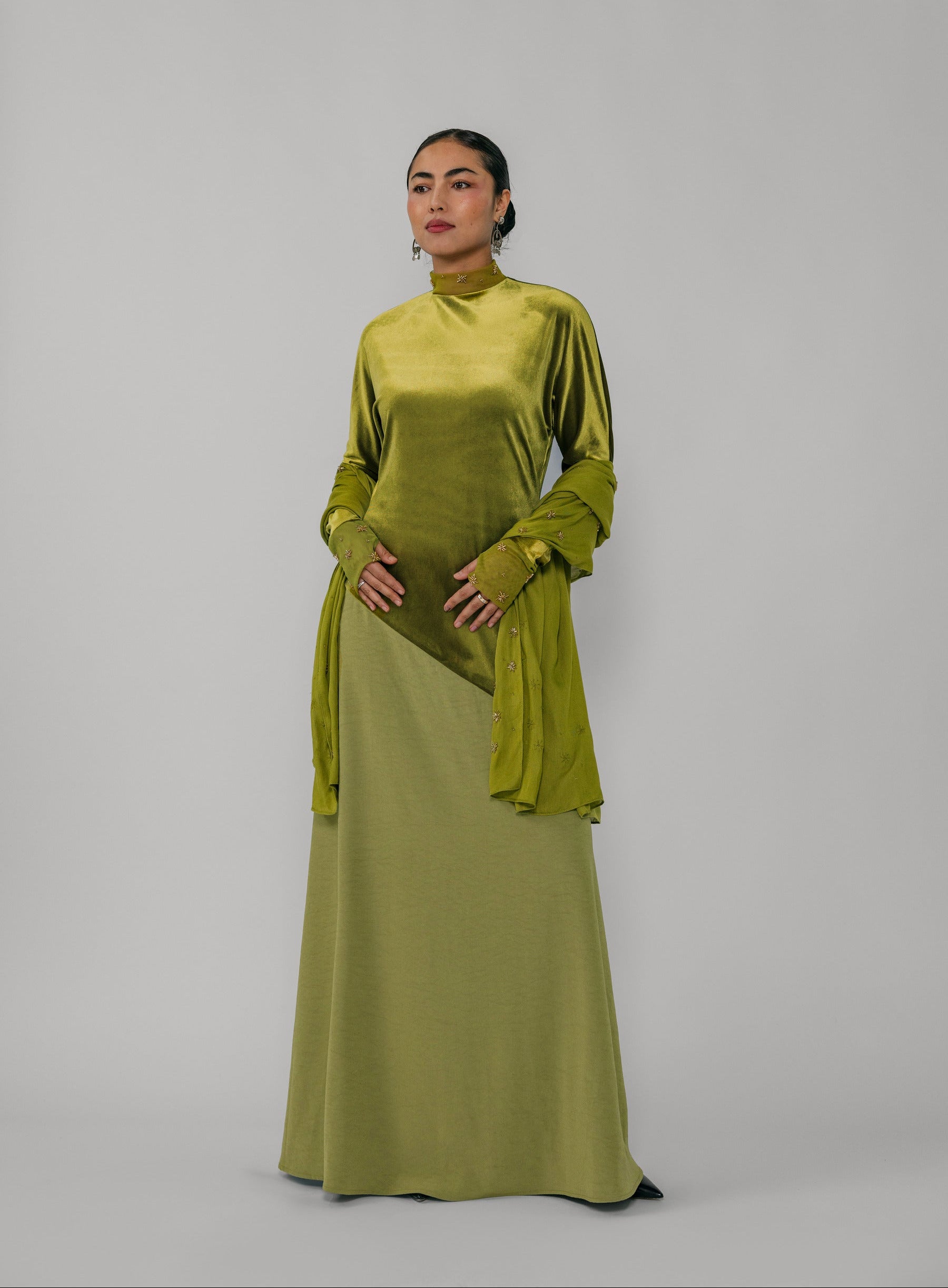 Woman wearing a green dress with a plain background