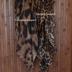 Print comparison of two leopard print hijabs labeled 'Chocolate Leopard' and 'Espresso Leopard' on a wooden background.