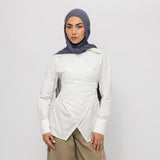 Woman wearing a white long-sleeve top and beige pants with a gray hijab on a white background