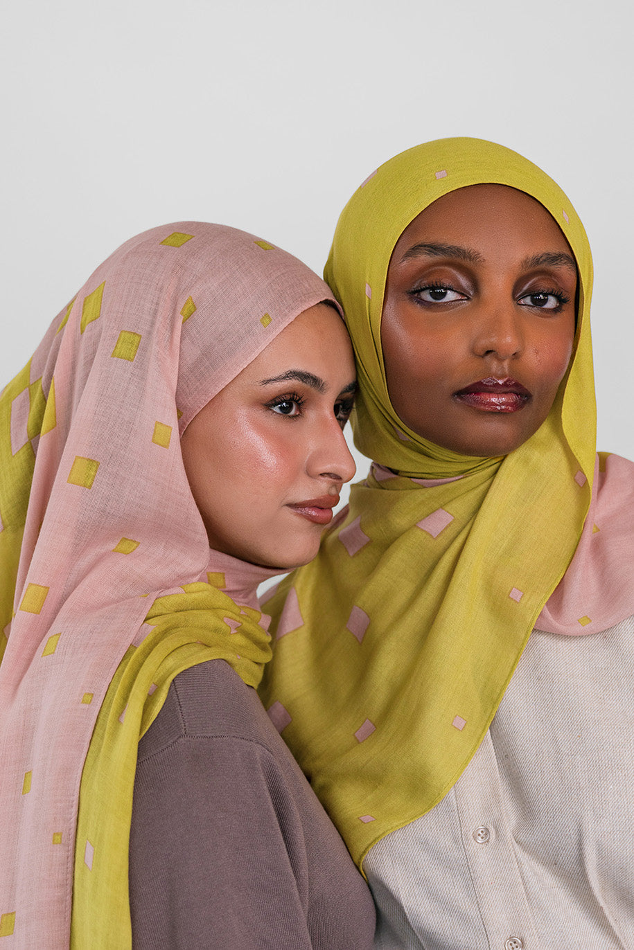 Two women wearing hijabs with a citrine polka dot pattern on a white background