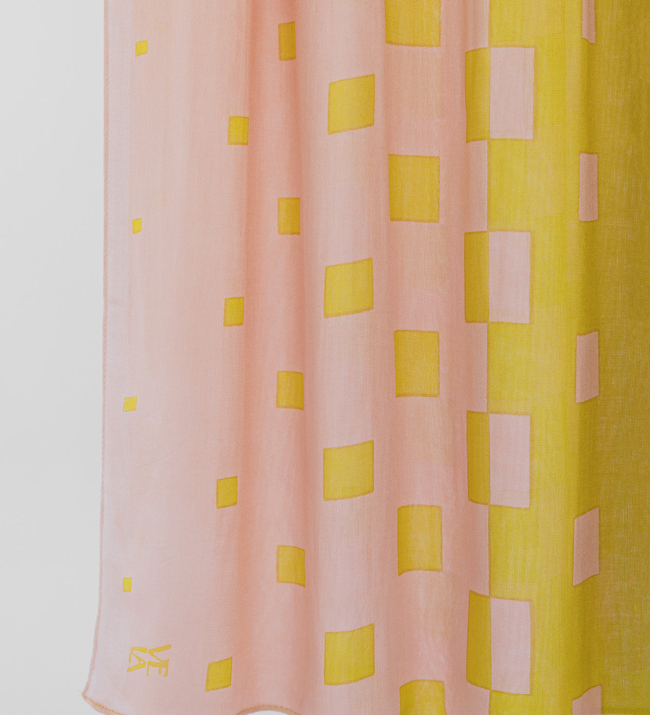 Pink and yellow checkered fabric with a visible brand logo on a white background