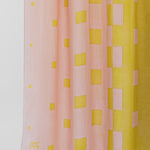 Pink and yellow checkered fabric with a visible brand logo on a white background