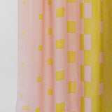 Pink and yellow checkered fabric with a visible brand logo on a white background