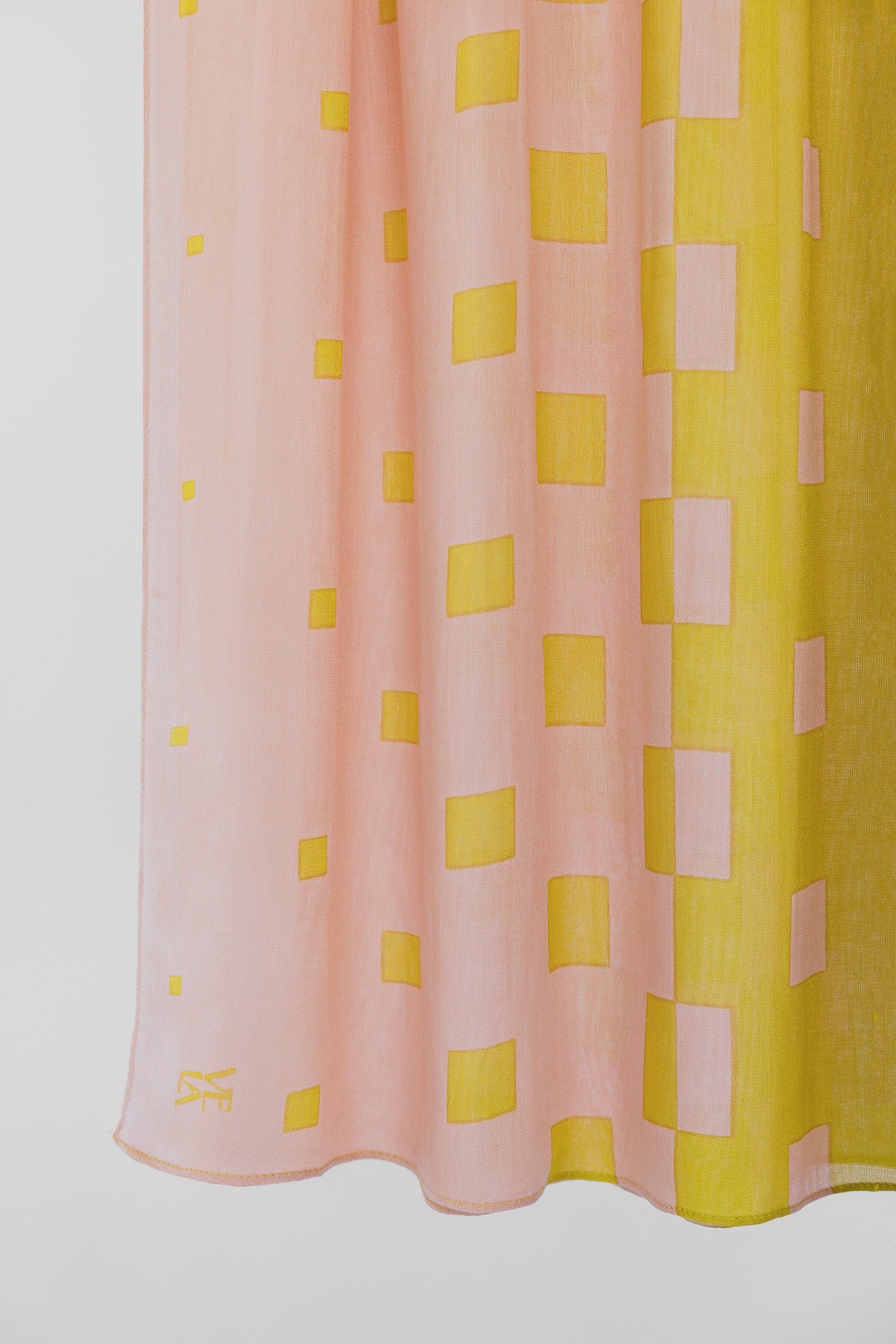 Pink and yellow checkered fabric with a visible brand logo on a white background