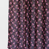 Dark purple fabric with pink polka dot pattern on a white background