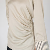 Beige long-sleeve top with striped cuffs on a white background