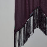 A dark plum purple fabric panel with long black fringe trim along the jagged curved bottom edge, shown against a plain light gray background.