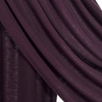 A close-up of draped dark plum purple fabric with a subtle sheen, showing the texture and folds against a white background.