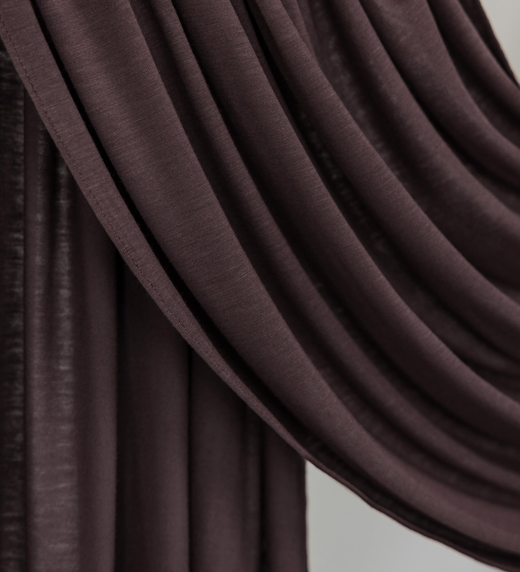 Close-up of a draped brown fabric against a neutral background