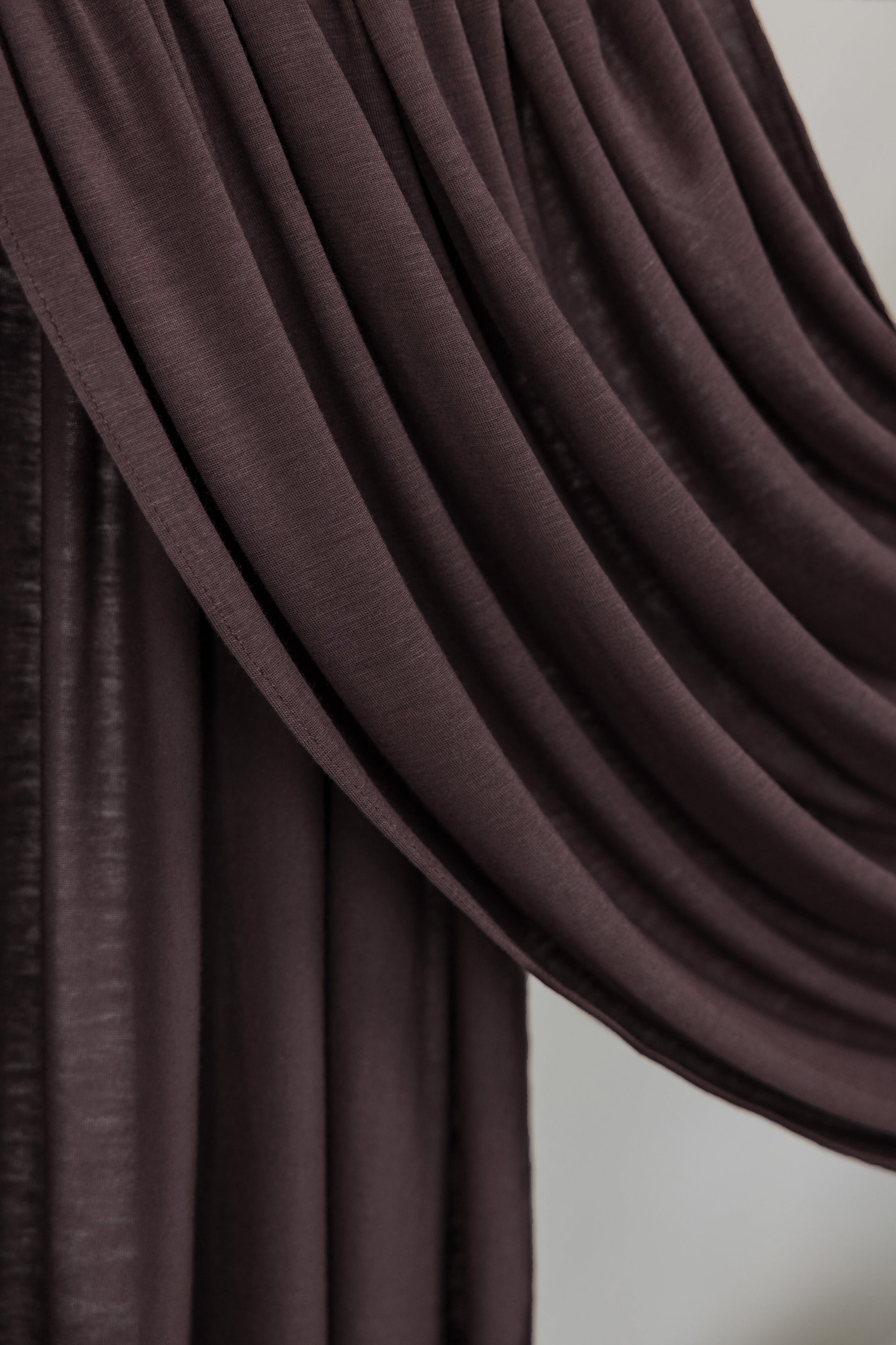Close-up of a draped brown fabric against a neutral background