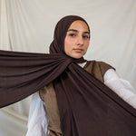 Woman wearing a brown hijab with a white background