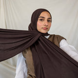 Woman wearing a brown hijab with a white background