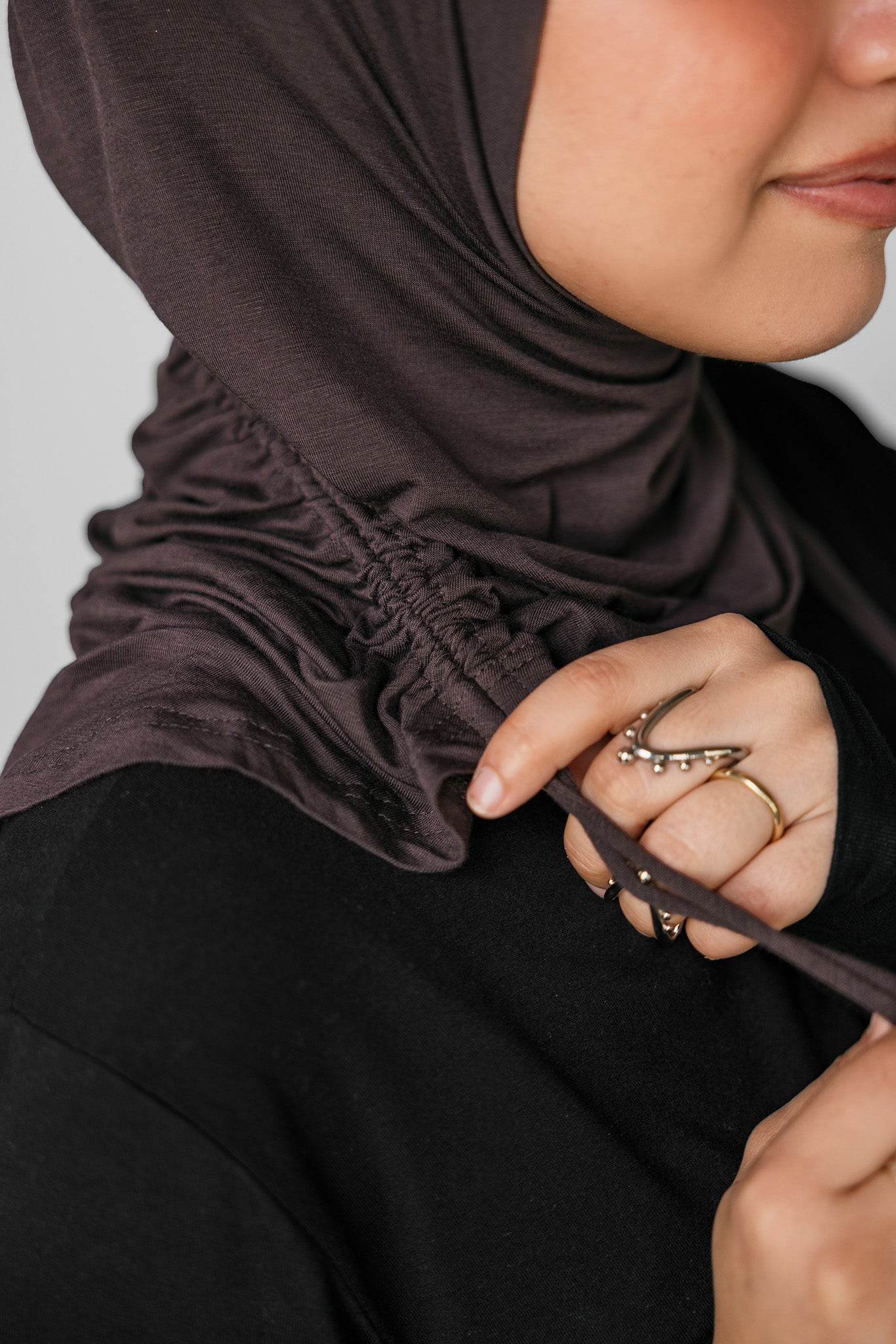 Person wearing a brown hijab with a neutral background