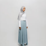 Woman wearing a light gray hijab, white top, and light blue skirt on a white background