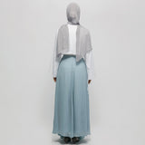 Person wearing a light gray hijab, white top, and light blue skirt on a white background