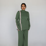 Person wearing a green outfit with a pink stripe on a white background
