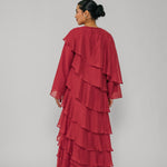 Woman wearing a red layered dress on a gray background