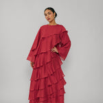 Woman wearing a red layered dress on a gray background