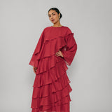 Woman wearing a red layered dress on a gray background