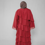 Red layered dress with a hijab on a plain background