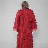 Red layered dress with a hijab on a plain background