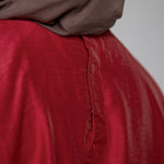 Red garment with a brown hijab on a plain background